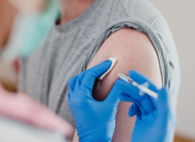 Close up of flu vaccine administered in a man's arm