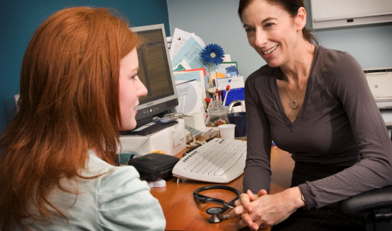 Doctor talking to patient over the internet on computer