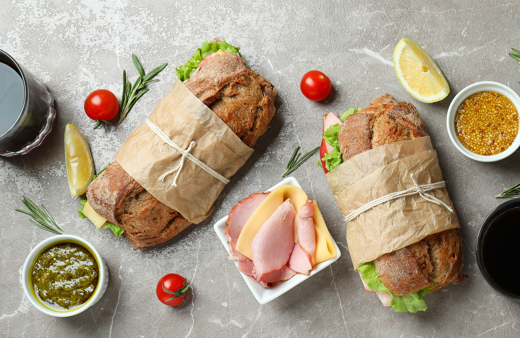 Lunch sandwiches and condiments laid out on a board.