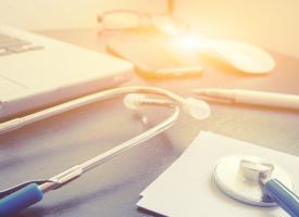 stethoscope and laptop on a desk