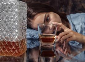 sad woman looking at alcohol