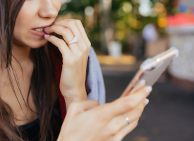 Woman looking worried while reading on her phone