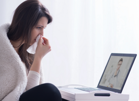 Sick woman looking at computer