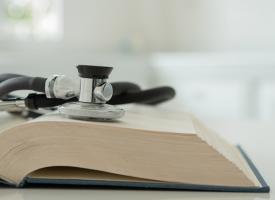 Stethoscope on top of open book