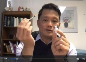 Dr Chris Moy holding a syringe 