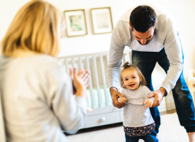 Parents with baby learning to walk