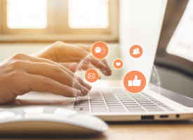 Person using laptop with social media icons
