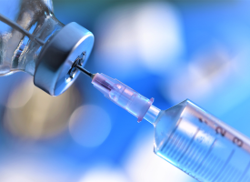 Needle being filled with vaccine