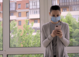 Woman using phone while wearing face mask