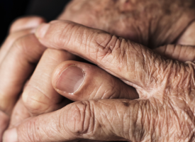 aged hands clasped 