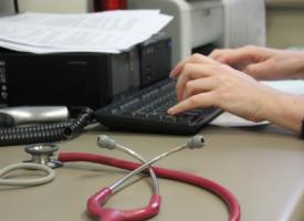 Doctor views computer at desk