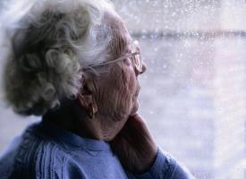 senior woman looking out window 