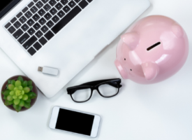 Image of piggy bank next to computer