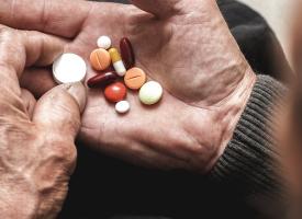 elderly person holding pills