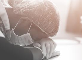 tired doctor sleeping with head on desk