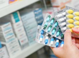 Person's hands holding pill packets 