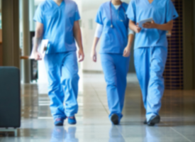 shot of doctors walking in blue scrubs but heads not visible 