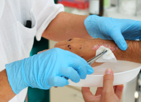 Doctor administering wound care to a patient's arm 