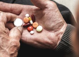 elderly person holding pills