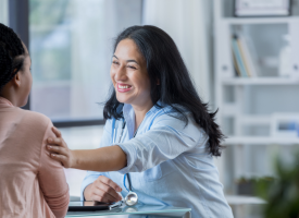 Female doctor with arm outreached to a patient 