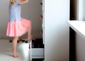 child climbing on chest of drawers