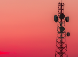 A telecommunications tower with pink sunset behind 