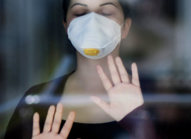 Woman in mask against glass