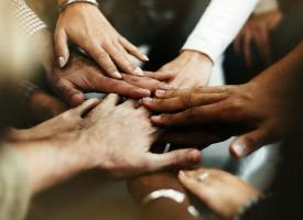 A diverse range of hands linked together. 