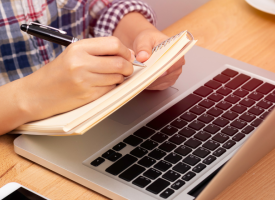 Person taking notes at computer