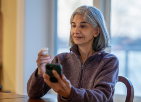 Woman holding medicine while on a video call