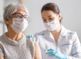 Doctor gives elderly lady a vaccine