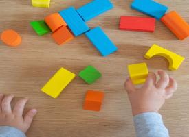 Child's hands playing with wooden blocks