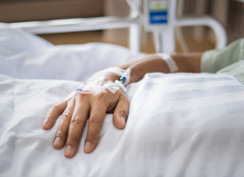 Hand of patient lying in a hospital bed