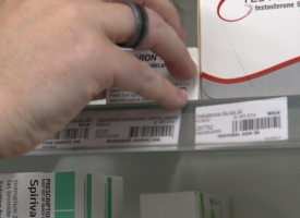 Pharmacist taking medication from shelf