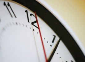 Close up of part of a clock face with the second hand on 12