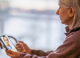 Woman holding a phone on a video telehealth appointment