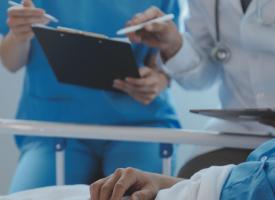 Image of medical staff conferring over patient