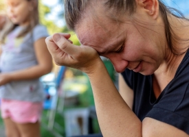 Image of sad woman with blurred children in background