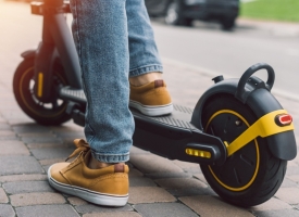 Image of man's feet on an e-scooter