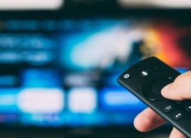 Remote control being used for TV 
