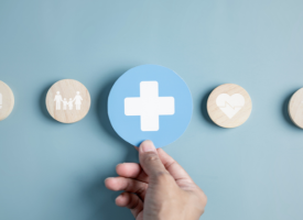Person's hand holding plus symbol and healthcare medical icon