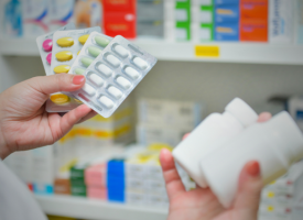 Close up of pharmacist inspecting medicines. Hands visible only