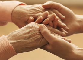A pair of hands holding a pair of older hands