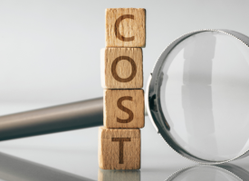 Magnifying glass and tower of blocks spelling out cost