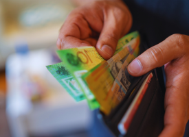 Hands opening wallet full of bank notes