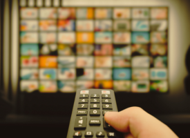 picture of someone holding remote in front of TV screen