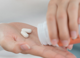 image of a person with pills in their hands