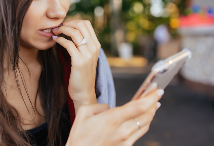 Woman looking worried while reading on her phone