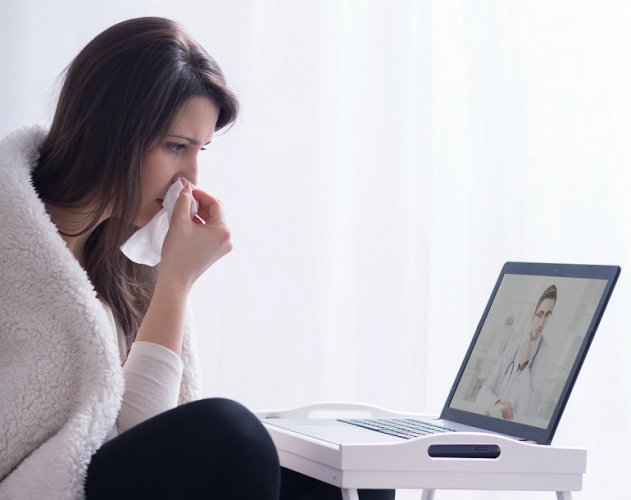 Sick woman looking at computer