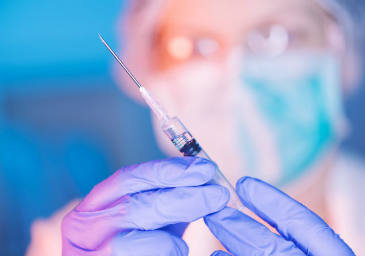 Person holding needle for vaccination